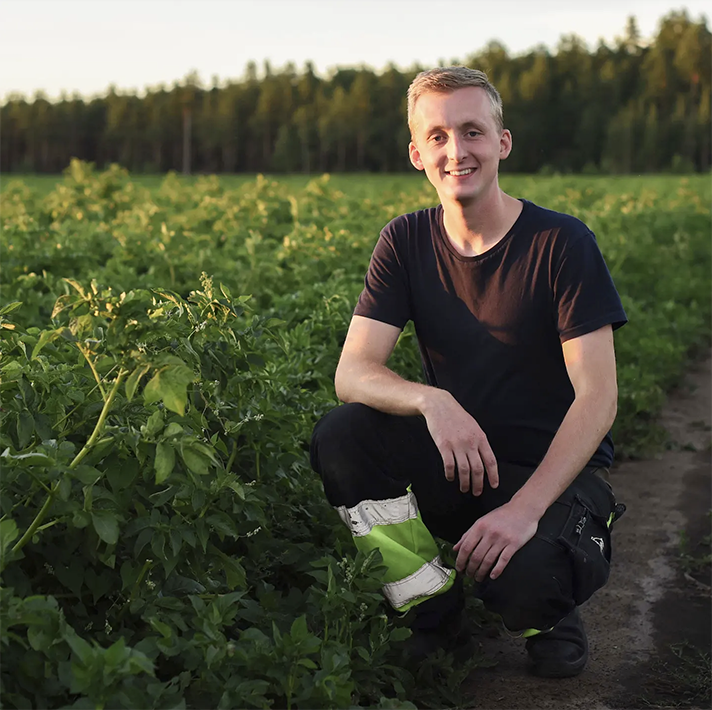 Filip bland potatisodlingarna, han ler mot kameran.