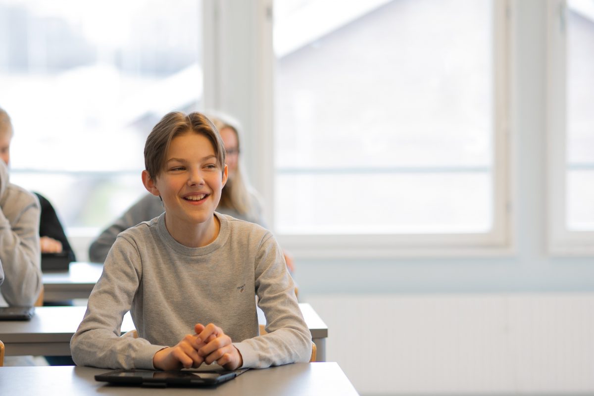 Glad elev i klassrum under lektion